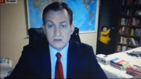 Picture of man speaking on video call with children coming into room in background